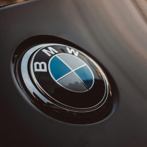 Close-up of a shiny BMW logo on a luxury car, emphasizing modern design.